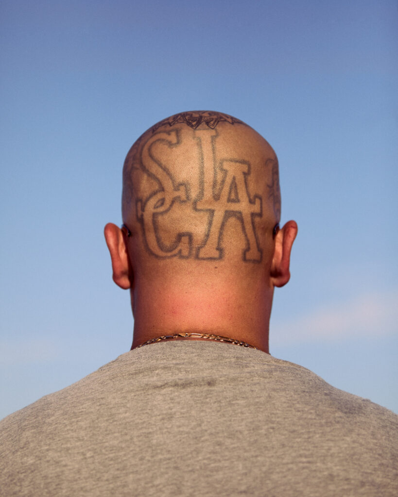 © Owen Harvey, 'South Central Los Angeles head tattoo. An ex gang member stands'